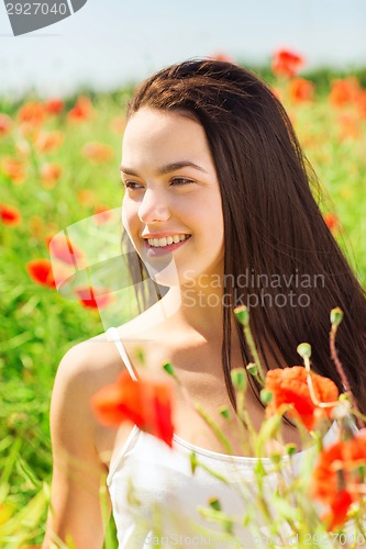 Image of smiling young woman on poppy field