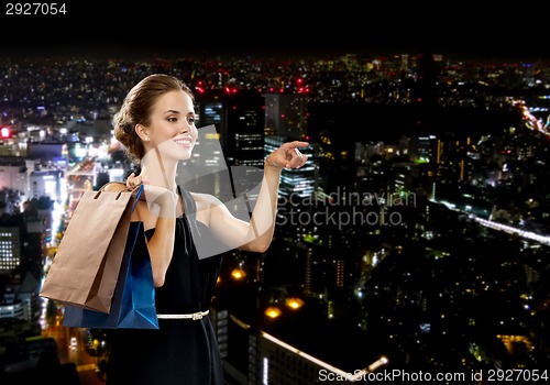 Image of smiling woman in dress with shopping bags