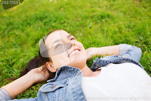 Image of smiling young girl lying on grass
