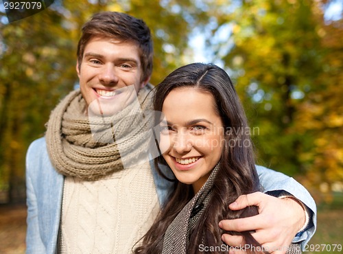 Image of smiling couple hugging in autumn park