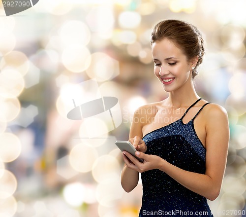 Image of smiling woman in evening dress with smartphone