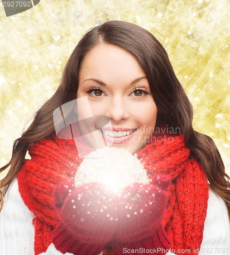 Image of smiling woman in winter clothes with snowball