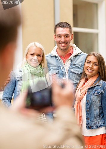 Image of group of smiling friends taking photo outdoors