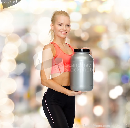 Image of smiling sporty woman with jar of protein