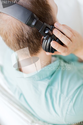 Image of close up of man in headphones at home