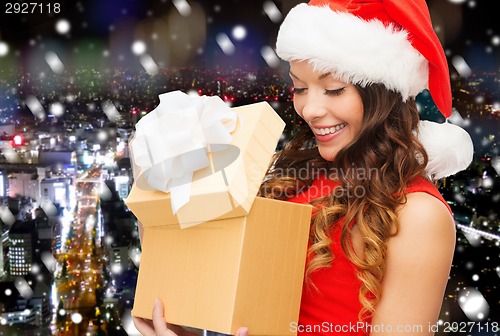 Image of smiling woman in santa helper hat with gift box