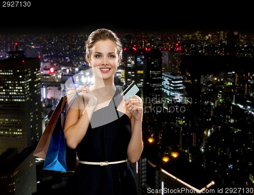 Image of smiling woman with shopping bags and credit card