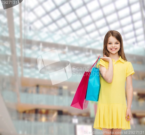 Image of smiling little girl in dress with shopping bags