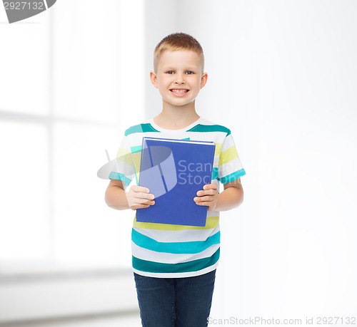 Image of smiling little student boy with blue book