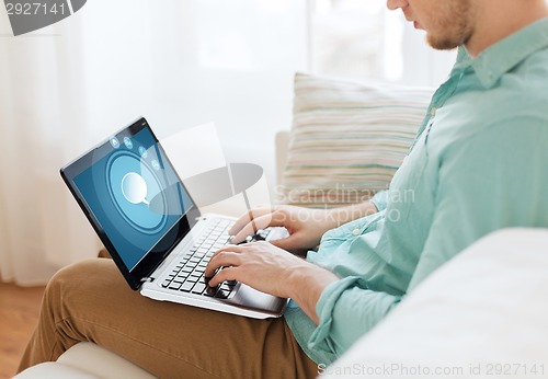 Image of close up of man working with laptop at home