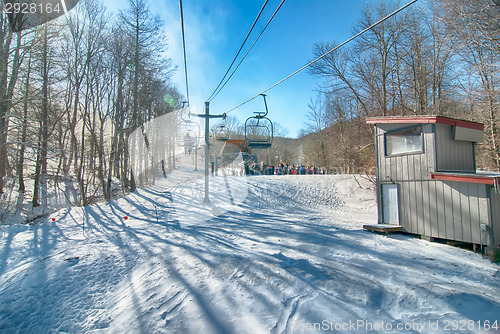 Image of Ski lift with seats going over the mountain
