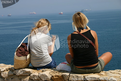 Image of Two girls sitting by the sea