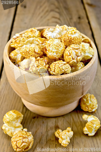 Image of Popcorn caramel in wooden bowl on board