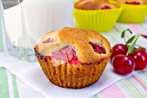 Image of Cupcake with cherries and milk on napkin