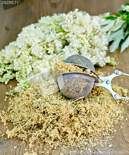 Image of Herbal tea of meadowsweet in strainer on board