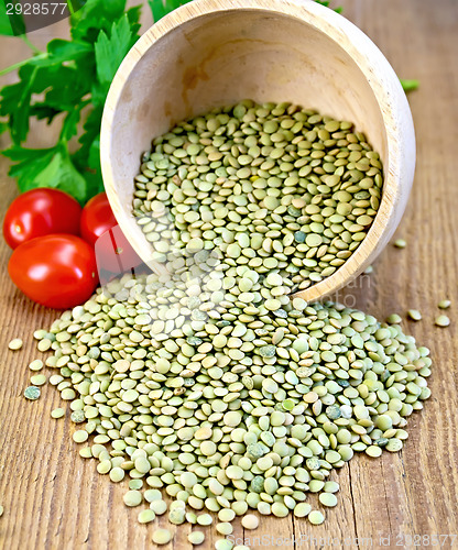 Image of Lentils green in bowl with tomatoes on board