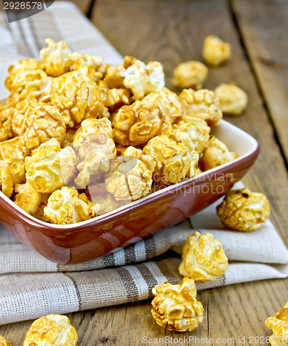 Image of Popcorn caramel on board in clay bowl with napkin