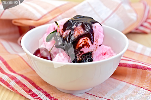 Image of Ice cream cherry with chocolate syrup on napkin