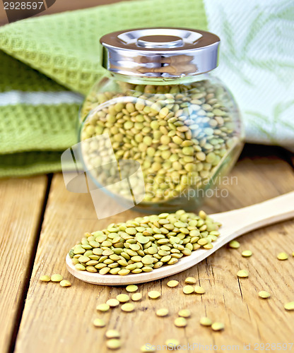 Image of Lentils green in jar and spoon with napkin on board