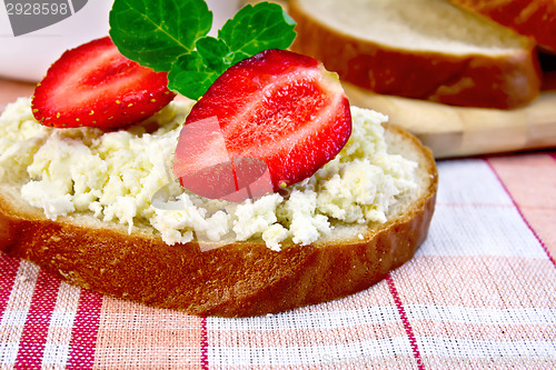 Image of Bread with curd and strawberries on red fabric