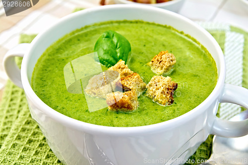 Image of Soup puree with spinach leaves and spoon on napkin