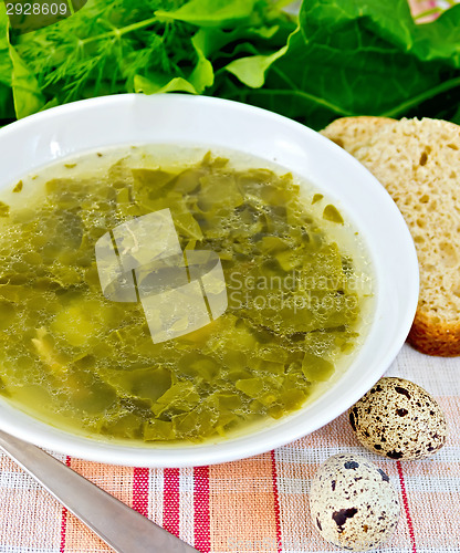 Image of Soup of greenery on fabric with bread