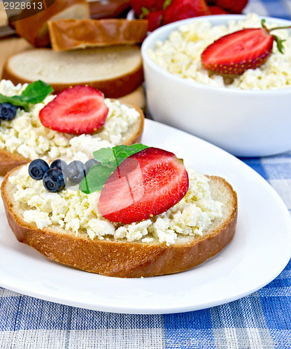 Image of Bread with curd and berries on blue cloth