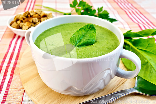 Image of Soup puree with spinach leaves on fabric