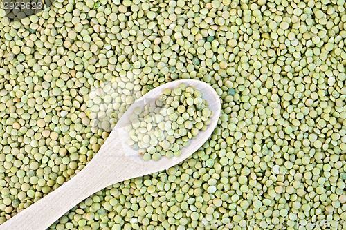 Image of Lentils green texture with a wooden spoon