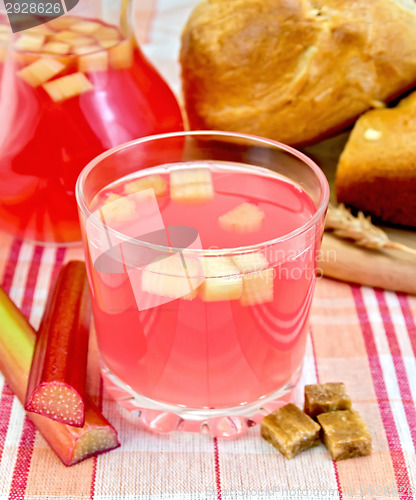 Image of Compote from rhubarb in glass and jug on cloth with bread 