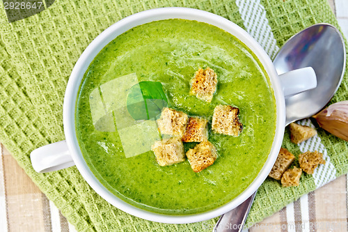Image of Soup puree with crackers and spoon on napkin