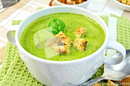 Image of Soup puree with spinach and spoon on a napkin