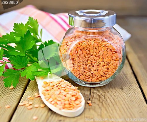 Image of Lentils red in jar and spoon with parsley on board