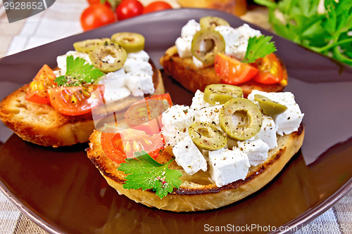 Image of Sandwich with feta and olives on tablecloth