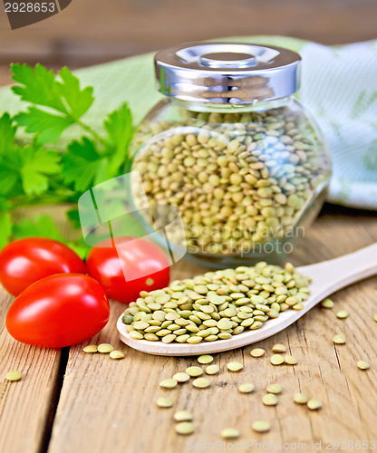 Image of Lentils green in jar and spoon with tomatoes on board