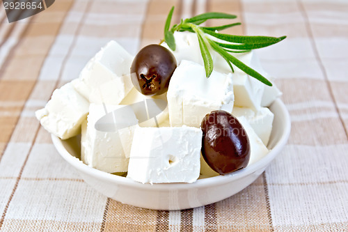 Image of Feta with olives in cup on brown cloth