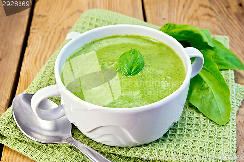 Image of Soup puree with spinach leaves on board