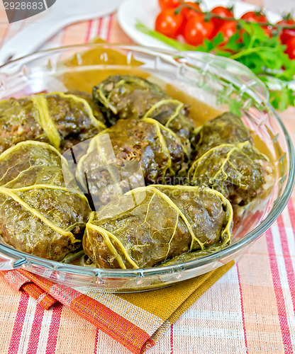 Image of Rhubarb leaves stuffed in glass dish on fabric