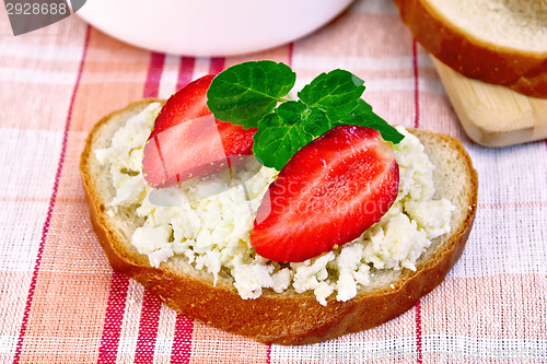 Image of Bread with curd and strawberries on red napkin