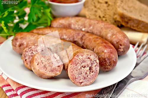 Image of Sausages pork fried in plate on board with parsley