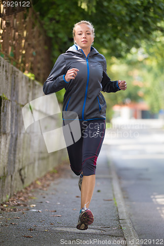 Image of Pretty young girl runner on the street.