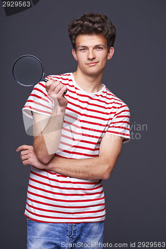 Image of Smiling man holding magnifying glass