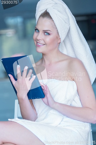 Image of Woman in Bath Towel Holding Tablet Computer