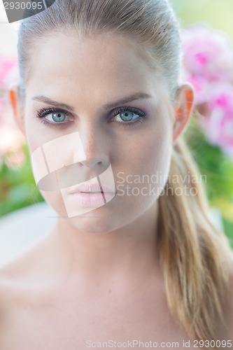 Image of Woman with Hair Pulled Back Looking at Camera