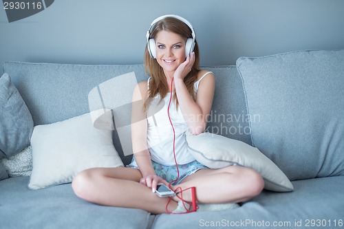 Image of Pretty young woman relaxing listening to music