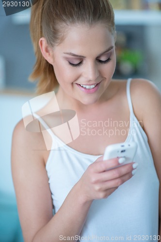 Image of Young Woman Looking Down at Cell Phone