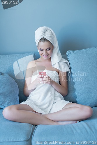 Image of Young Woman Wearing Bath Towel with Red Cell Phone