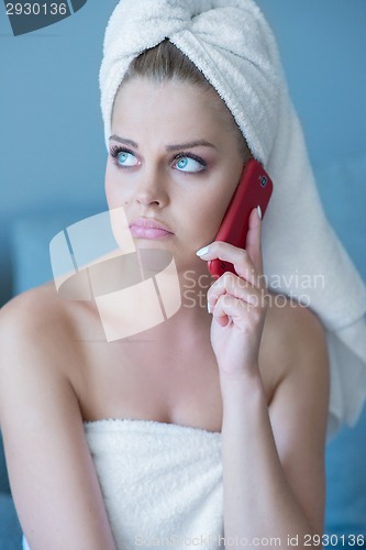 Image of Pouting Woman in Bath Towel with Red Cell Phone