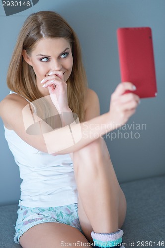 Image of Woman Smiling and Looking Up at Tablet Computer