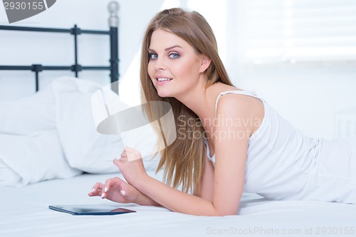 Image of Girl lying on her stomach in bed